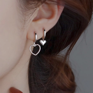 Detail of silver heart tassel earrings worn by a model in a trendy Korean retro style