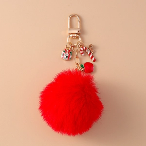 Detail of red faux rabbit fur keychain with gold Christmas gift and candy cane charms