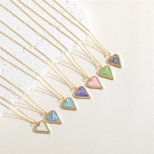 Macro shot of colorful heart-shaped shell pendants with pavé zircon borders on gold chains