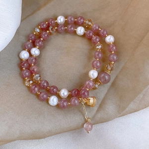 Bracelet multicouche en quartz fraise et perles d'eau douce avec breloque cloche dorée