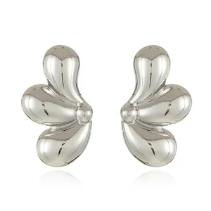 Macro detail of silver-finish water drop earrings featuring liquid metal geometric design