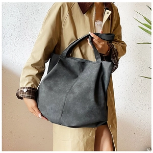 Macro detail of dark grey tote bag featuring vintage matte texture and vertical stitching