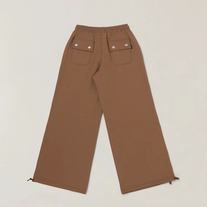 Detail of cargo pants showing elastic waistband and back flap pocket with metal snap