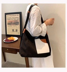 Canvas tote bag with white front pocket and brown leather straps in retro lifestyle setting