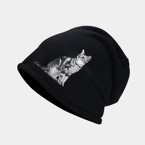 Détail de la maille et de l'imprimé chat gris réaliste sur le bonnet noir tricoté