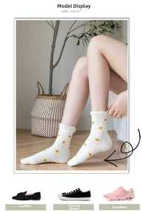 Detail of white cotton socks with yellow flower embroidery and frill trim cuffs
