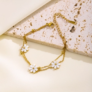 Elegant gold double-layered chain bracelet featuring white daisies and gold beads décor