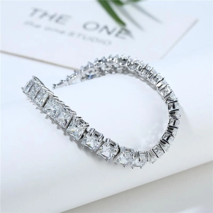 Silver-toned tennis bracelet featuring square-cut cubic zirconia on a white pedestal