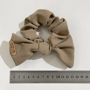 Khaki handmade bow scrunchie with bear label, oversized hair tie showing 14cm size scale
