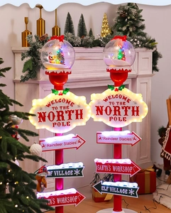 Illuminated Christmas street sign decor with glowing Santa globe and directional arrows