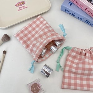 Close-up of pink checkered drawstring storage bags with pastel ribbons for cosmetics
