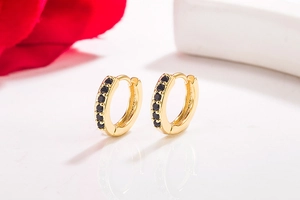 Close-up of 14K gold-plated hoop earrings featuring a row of black sparkling crystals