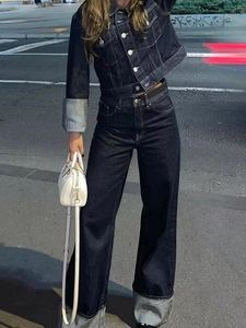 Détail d'un ensemble en jean bleu foncé avec veste et pantalon large et sac à main blanc