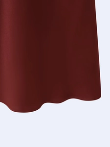 Close-up of the asymmetric wavy hemline on this chic reddish-brown satin midi dress