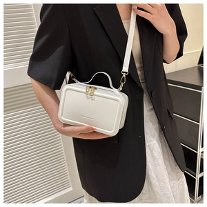 Detail of white mini suitcase bag with dual gold zippers and top handle strap