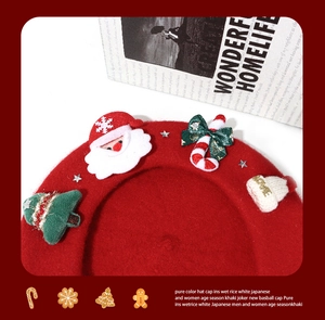 Close-up of red wool beret featuring 3D Christmas tree, Santa, and bow tie decorations