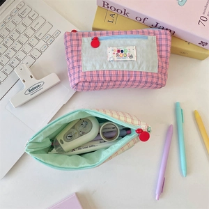 Macro shot of large capacity checkered fabric pencil cases with multiple stationery items
