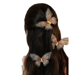 Three gradient brown mesh butterfly hair clips with pearls on model dark wavy hair