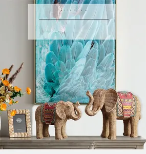 Détail de statues d'éléphants tressées avec motifs ethniques sur un meuble gris chic