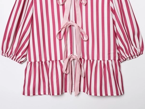 Detail of red and white striped shirt featuring pink ribbon bows and ruffled hemline