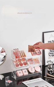 Detailed view of clear acrylic cosmetic organizer with tiered tilted slots for makeup