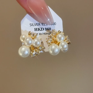 Detailed macro view of gold plated cluster earrings featuring 925 silver needles and pearls
