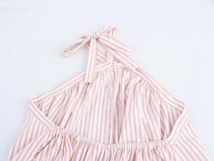 Detailed flat lay of striped halter neck top with tie back detail on white fabric