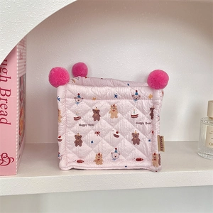 Detail of pink quilted storage basket with Happy Bear cartoon print and pom-poms