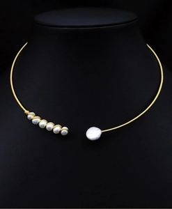 Detail of a gold choker featuring a cluster of small pearls and a large coin pearl
