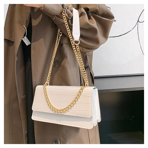 Détail du sac blanc à motif crocodile avec chaîne dorée et structure en accordéon