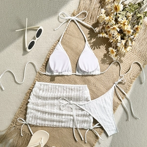 Detaillierte Flachbildaufnahme eines weißen Bikini-Sets mit strukturiertem Mesh-Pareo
