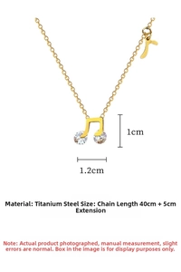 Detailed view of musical note pendant in gold titanium steel with crystal accents