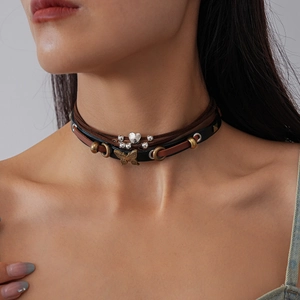 Detail of layered brown suede choker with bronze butterfly and silver heart pendants
