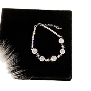 Elegant zircon flower bracelet with white chalcedony stones on a black velvet display
