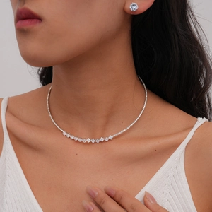 Macro detail of silver zircon geometric necklace and stud earrings set on a model