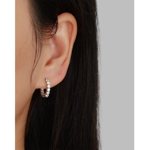 Close-up of s925 sterling silver huggie hoop earrings with sparkling cubic zirconia pavé