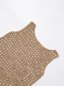 Détail de l'encolure du gilet en tricot marron clair à paillettes et crochet