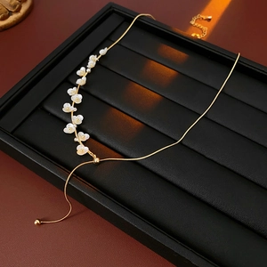 Detail of gold flower necklace with white pearls and adjustable pull-out chain clasp