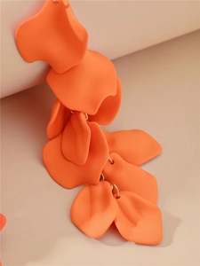 Détail de pétales de rose en résine orange mate sur de longues boucles d'oreilles