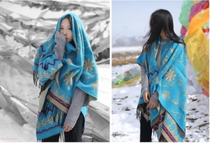 Close-up of ethnic blue cashmere shawl with floral patterns and black fringe details