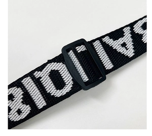 Close-up of wide woven shoulder strap with white letter embroidery and black plastic buckle