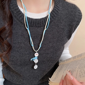 Détail du pendentif bonhomme de neige avec écharpe bleue sur cordon tressé