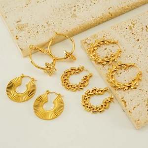 Macro shot of assorted 18K gold plated stainless steel hollow hoop earrings on stone