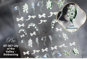 Détail macro des stickers ongles 3D en relief muguet et nœuds papillon modèle DT-007