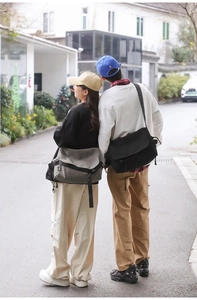 Outdoor shot of large canvas messenger bags in black and gray for casual daily use