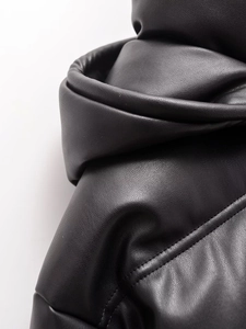 Détail rapproché de la texture du cuir noir et des surpiqûres de cette veste matelassée