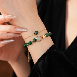 Macro shot of tiger eye stone beads and gold alloy link bracelets on a model's wrist