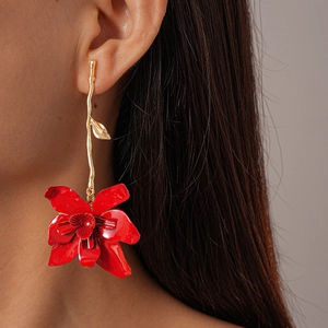 Close-up of elegant red flower drop earring on model with golden metal stem detail