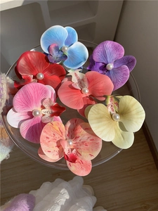Detailed macro view of colorful orchid hair clips featuring centered white pearls on petals