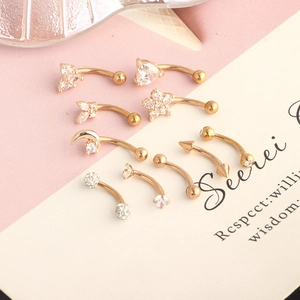 Detailed macro view of golden stainless steel eyebrow rings with heart and moon studs